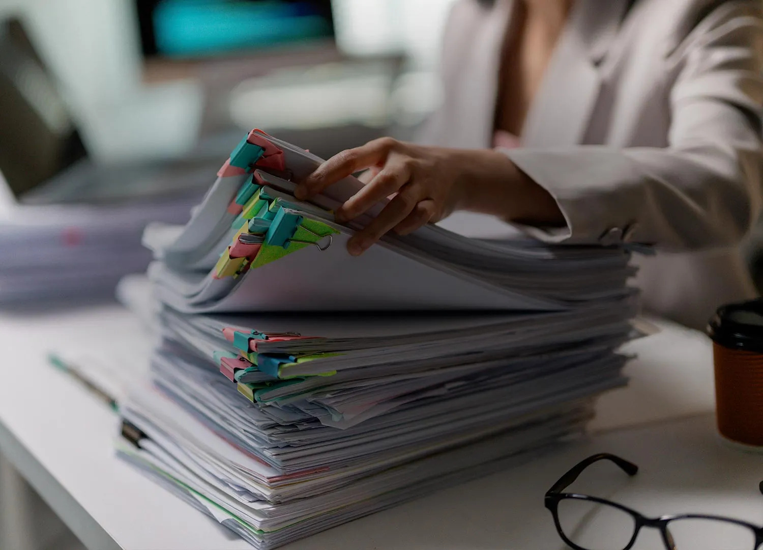 A stack of clipped export document files on a desk as an exporter works through paperwork.